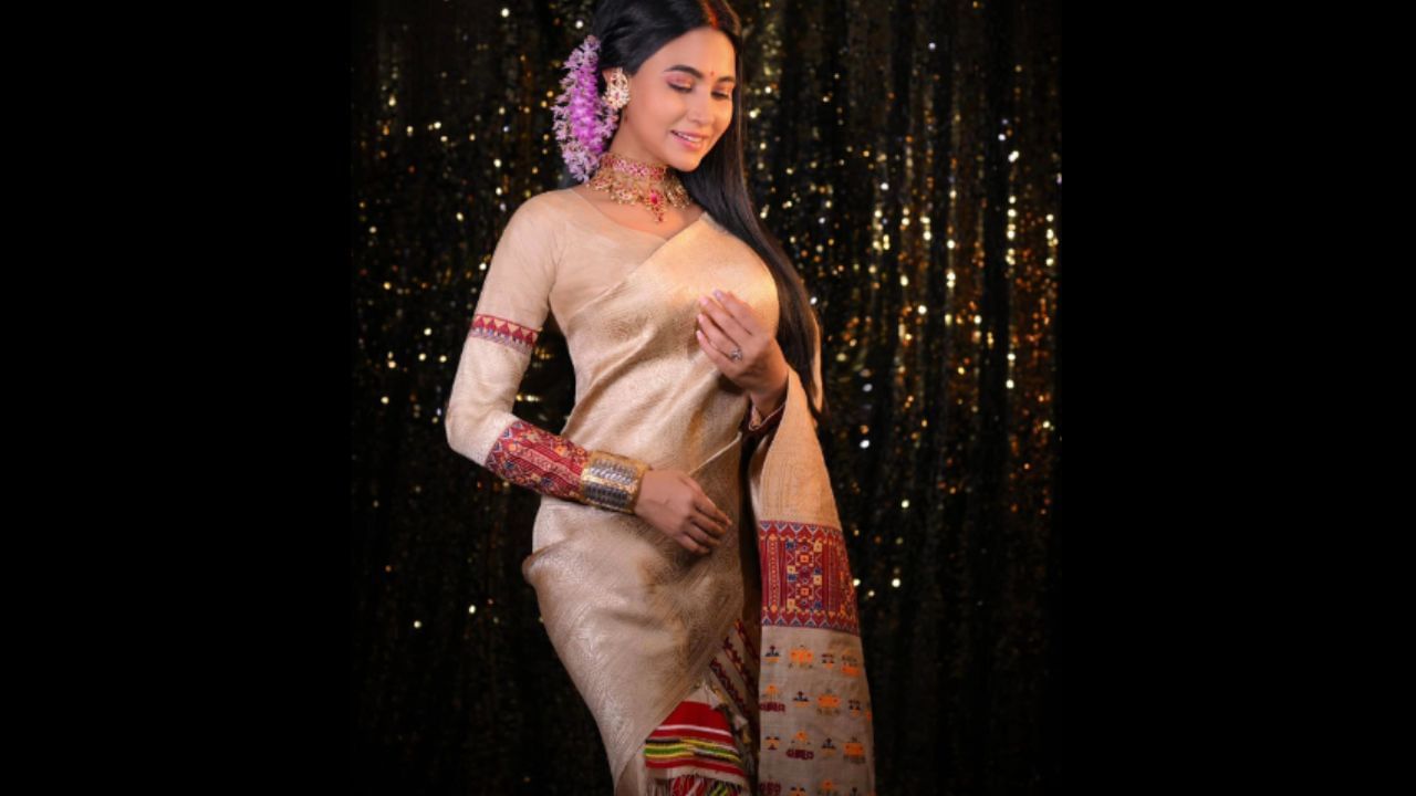 অভিনেত্ৰীগৰাকীৰ পিন্ধনত দুশ বছৰীয়া পুৰনি ফুল বছা মুগাৰ সাঁজ, হাতত গামখাৰু, অসমীয়া গামোছা, ৰিহা আৰু খোপাত কপৌফুল।