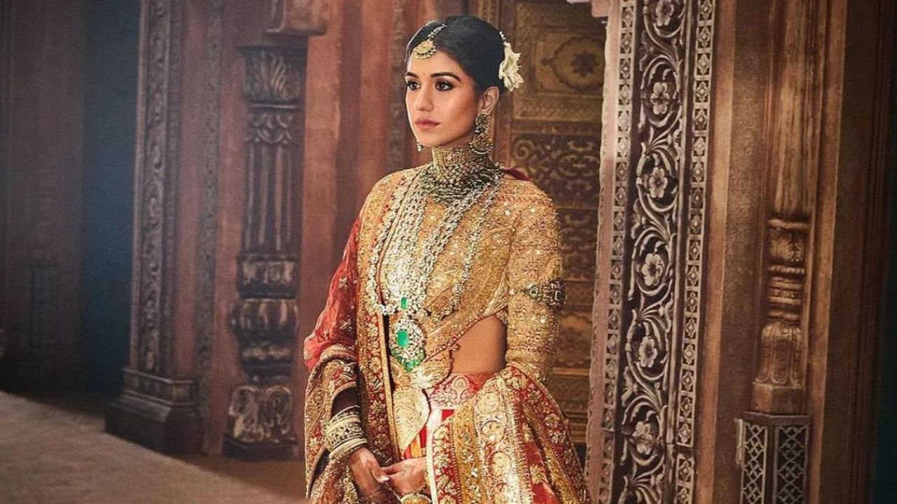 Radhika wedding look:১৯ শতিকাৰ শেষৰ ফালৰ শিল্পকলাক প্ৰতিফলিত কৰা ৰাধিকাৰ এনচেম্বলত ব্ৰকেড লেহেংগা স্কাৰ্ট, ৰেচমৰ দুপাট্টা আৰু ওৰণিও আছিল ।