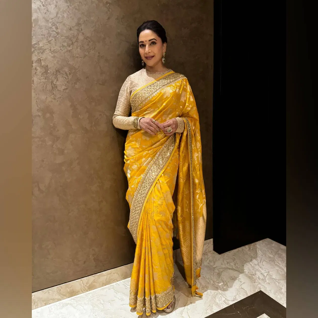 এই ফটোত অভিনেত্ৰীগৰাকীক হালধীয়া ৰঙৰ শাৰী পৰিধান কৰিছে।  ইয়াৰ লগতে সোণালী ৰঙৰ ব্লাউজ পৰিধান কৰিছে। চুলিখিনি বান্ধি ৰাখিছে। এনেকৈ শাৰী বা মেকআপ পূজা পাৰ্বন বা বিয়াৰ অনুষ্ঠানলৈ গ'লেও পিন্ধিব পাৰি।