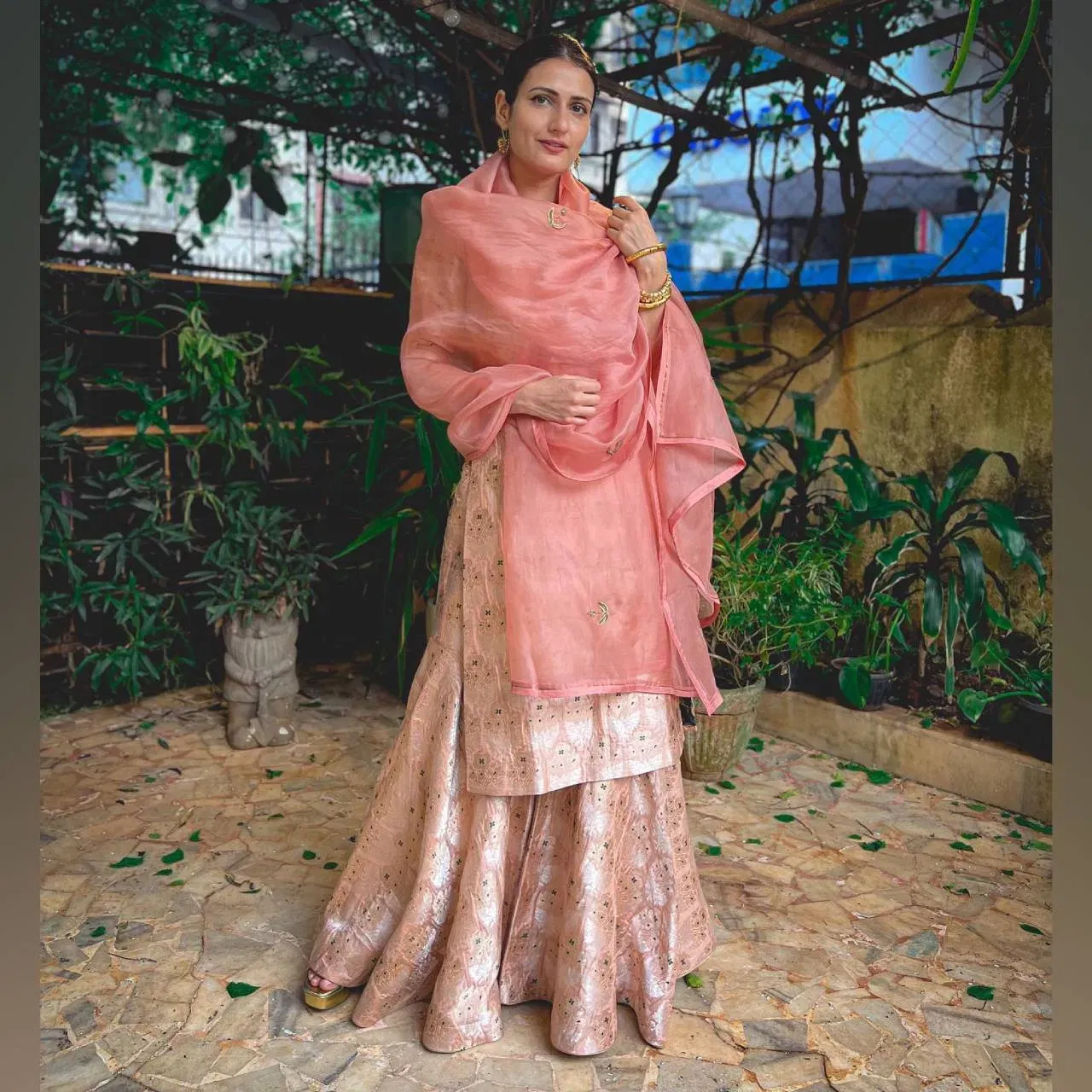 ফাতিমা চানা শ্বেইখৰ এই ছুট লুকটোত যথেষ্ঠ আকৰ্ষণীয় দেখা গৈছে। এনে গোলাপী ৰঙৰ বাণাৰসী শৰাৰা ষ্টাইলৰ চুট আপুনিও পুৰণি শাড়ীৰ পৰা চিলাব পাৰে।
