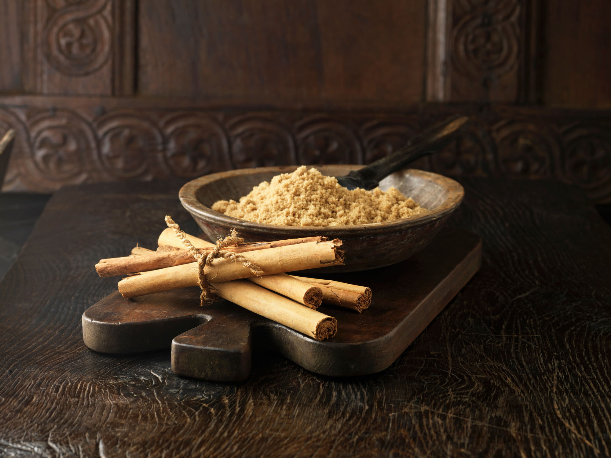 Ingredients For Dry Cure Sugar Glazed Gammon Joint. Cinnamon Sticks Tied With String And Brown Sugar In Wooden Bowl
